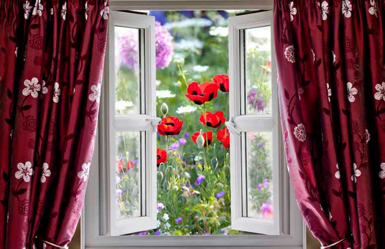 Punaiset kukkaverhot ja avoinainen ikkuna puutarhaan