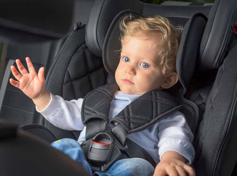 Lapsi istuu auton turvaistuimessa