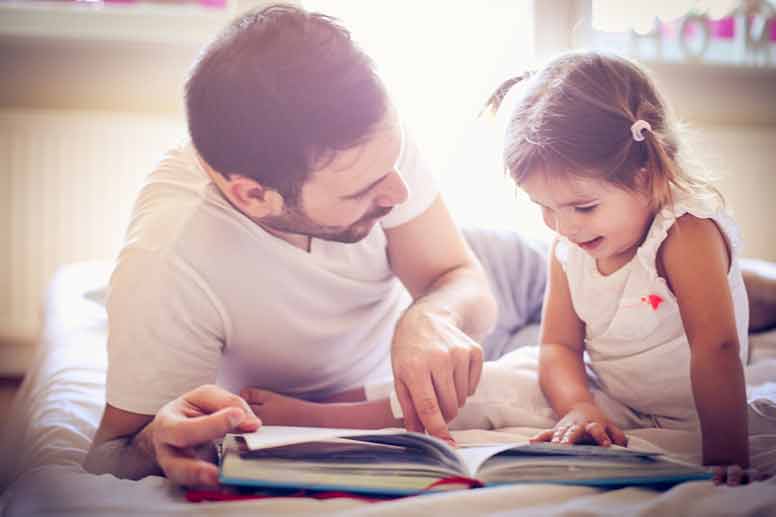Isä ja tytär lukevat satukirjaa