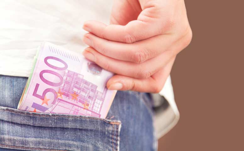Mies ottaa farkkujen taskusta euroja