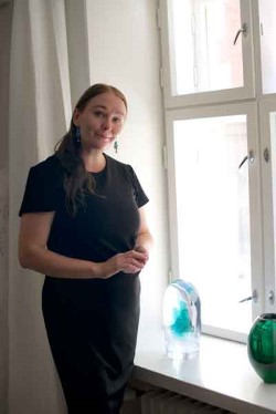 ”Suomalaisia tekijöitä on ollut vuosittain Venetsian lasiviikoilla mukana ja suomalainen lasi toki tunnetaan ennestään Italiassa. Tämän vuoden FRESH - Contemporary Glass From Finland -kokonaisuudessa ideana on tuoda suomalainen nykylasi ajankohtaisella ja läpileikkaavalla tavalla esille”, Sini Majuri kertoo. Sinin taustalla hänen teoksensa ”Cell”. Kuva: Heini Hanna Karhu