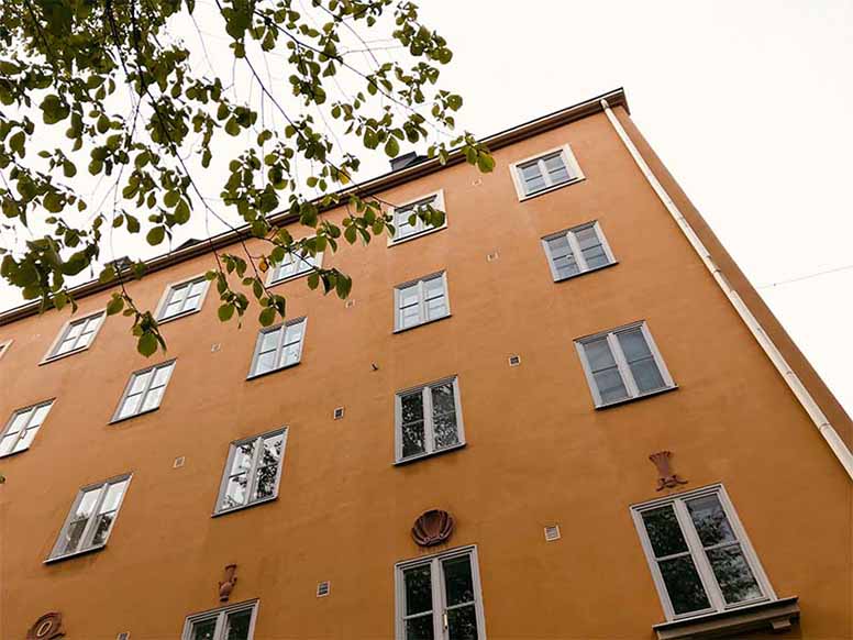 Keltainen kerrostalo ja puu Vallilassa