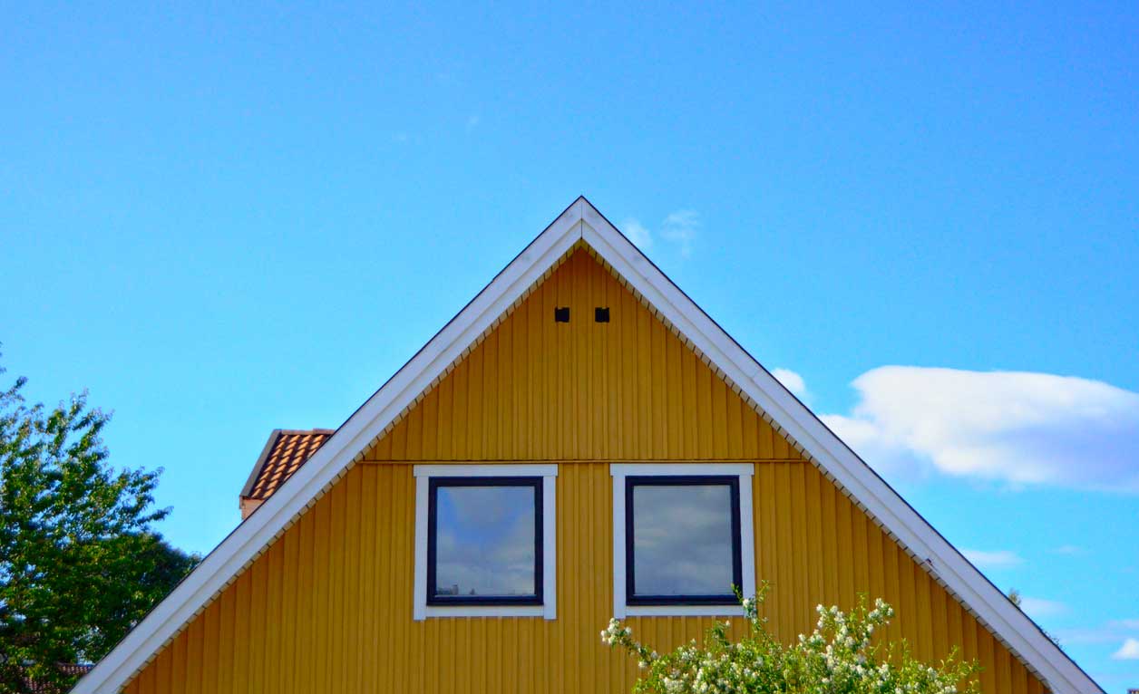 Keltainen omakotitalo ja sininen taivas