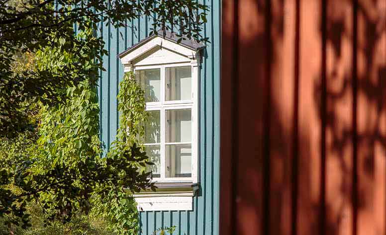 Sininen puutalo ja pensas