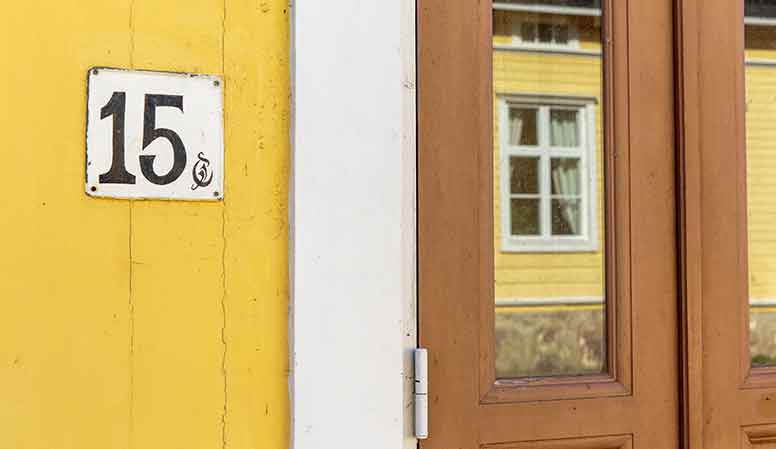 Keltainen puutalo ja ikkunassa heijastus