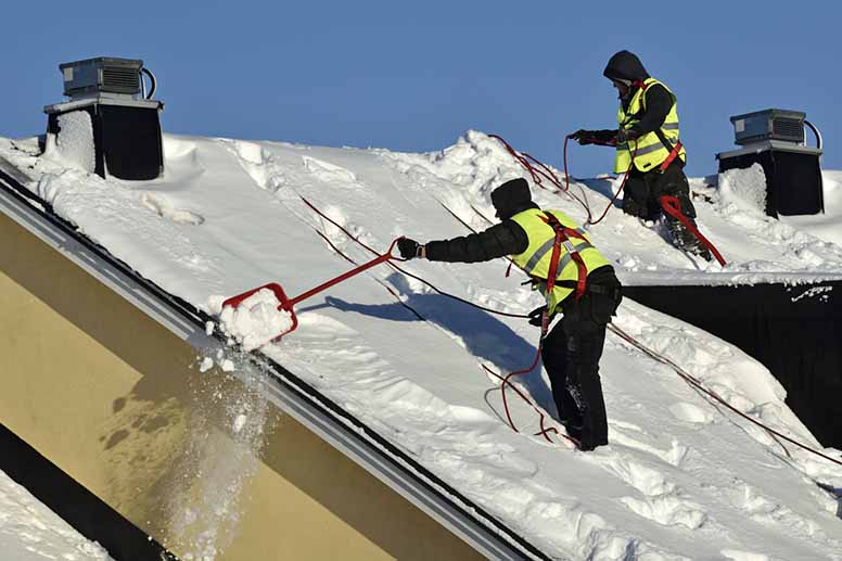 Lumenpudottajat pudottavat lunta katolta