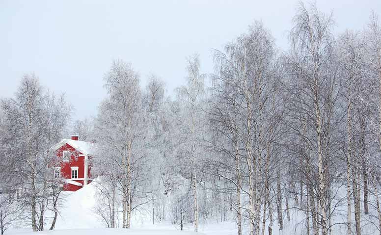 Punainen omakotitalo talvisessa maisemassa