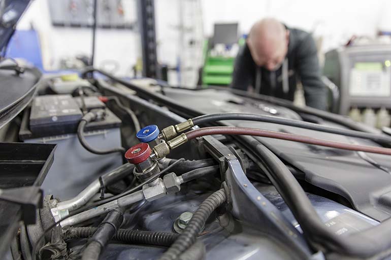 Huoltolaitteen letkut kytketään auton huoltoliittimiin, joiden kautta kone pääsee auton ilmastointijärjestelmään. Kuva: Patrik Lindström