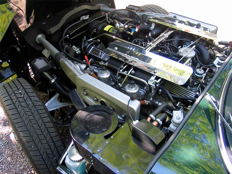 Jaguarin V12-konetta on pidetty yhtenä maailman hienostuneimmista moottoreista – ainakin englantilaisten mielestä. E-Typen konepeitto on yhtä etulokasuojien kanssa, ja koko komeus nousee ylös paljastaen myös etupyörät ja ripustukset. 