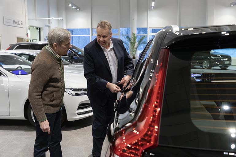 Automyyjä Jari Lindfors näyttää Sture Lindqvistille, miten avaimettomaan Volvoon pääsee avaimella sisään, jos auton akku on päässyt tyhjenemään tai avaimen kaukosäädin ei toimi. 