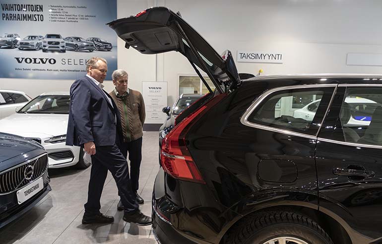 Automyyjä Jari Lindfors näyttää Sture Lindqvistille, miten Volvon takaluukku aukeaa jalan heilautuksella. 