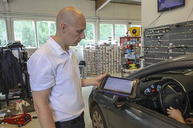 Autonavaimet-firman toimitusjohtaja Henrik Harberg esittelee laitetta, jolla auton ajonesto ohjelmoidaan. Kuva: Markus Nieminen
