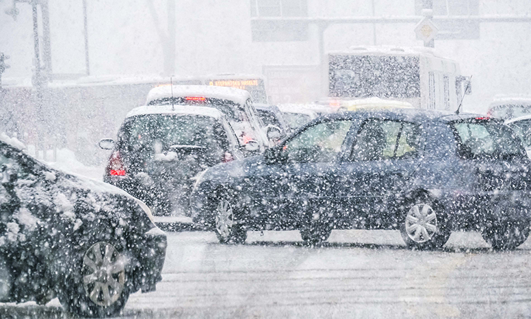 Mustia autoja lumimyräkässä