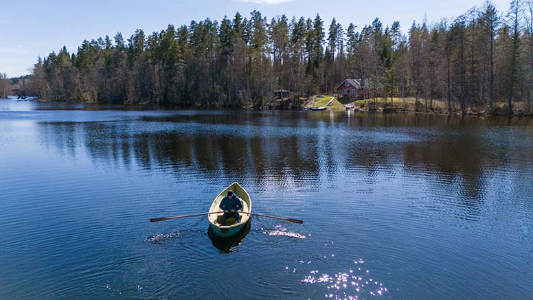 Mies soutaa veneellä kesämökille