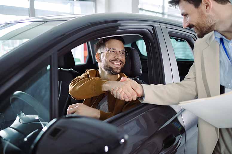 Asiakas ja myyjä autokaupassa