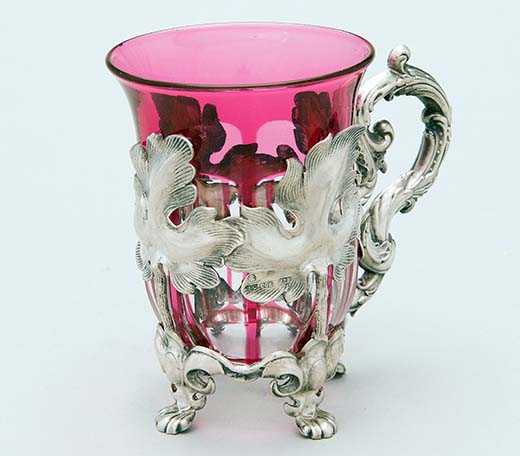 Bukowskisin Helsingin huutokaupassa oli tarjolla tämä uusrokokoota edustava, naisellisen siro hopeinen teelasinpidike, jossa on lävistetty lehtikoristelu. Pidikkeen sisällä on kirkas ja lila lasi, jossa on naarmu. Korkeus on 10,5 cm. Leimat ovat epäselvät, mutta hopeaseppä on Carl Gustav Ekqvist Pietarista. Valmistusajankohta on 1850-luku. Hinta nousi huutomaksuineen noin 900 euroon. Kuva Bukowskis