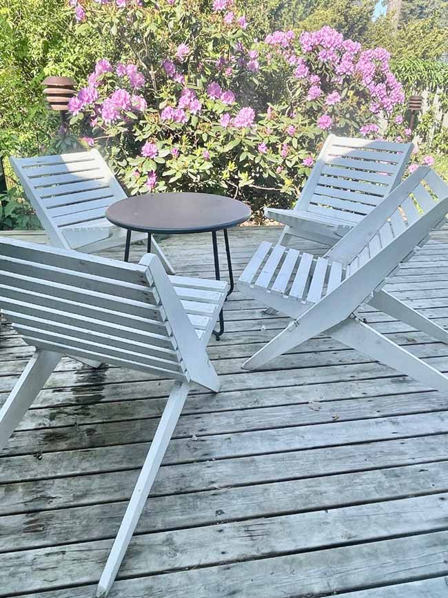 Löysin kauniit vaaleat kalusteet Hangon iltatorilta. Ne ovat vanhat ja itse tehdyt, mutta samantyylisiä valmistetaan nykyisin myös uustuotantona. Myös uusi pihavalaisin sopii aikakauden tyyliin. Terassi ei varsinaisesti kuulu 1960-luvun henkeen, tyylillisesti oikeaoppisempi valinta olisi liuskekivet. Kuva: Katja Weiland-Särmälä