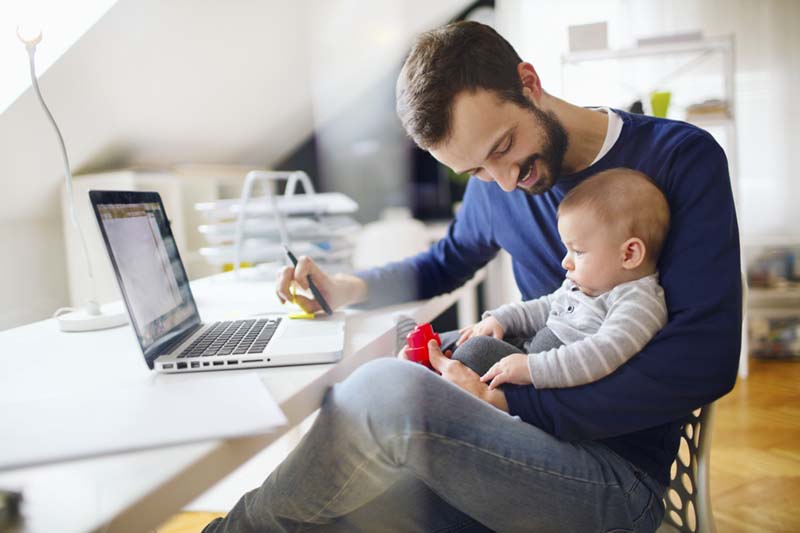 Mies ja vauva työskentelevät tietokoneella