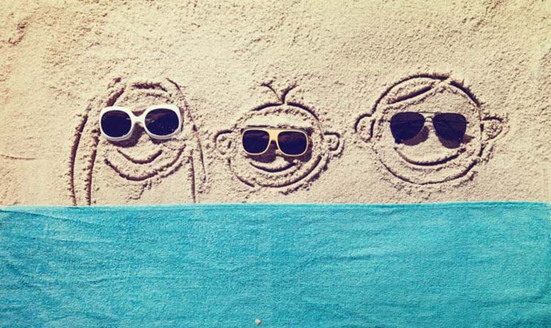 Hymynaamat ottavat aurinkoa rannalla