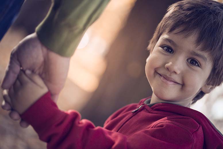 Poika pitää isää kiinni kädestä