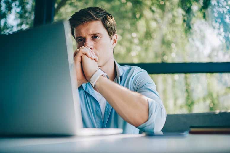 Mies katselee tietokoneen näyttöä