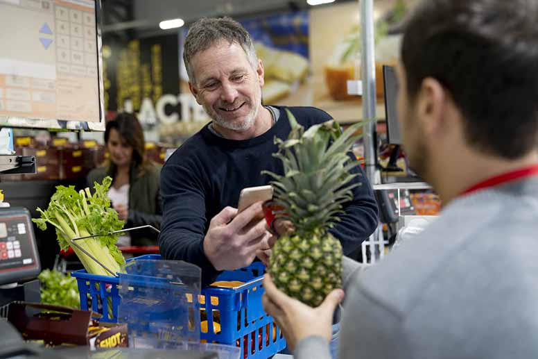 Mies ostaa ruokaa ruokakaupasta