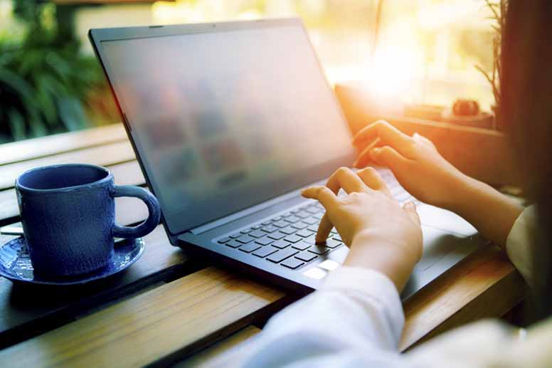 Nainen naputtelee kotona tietokonetta