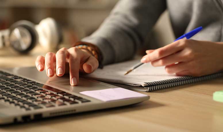 Kannettava tietokone, kädet ja kynä