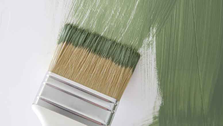 Maalarin maalisuti ja vihreää maalia