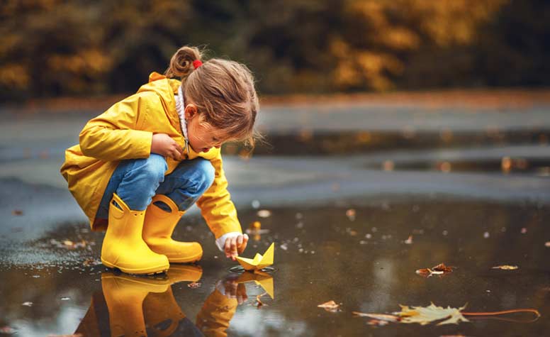 Tyttö leikkii lätäkössä