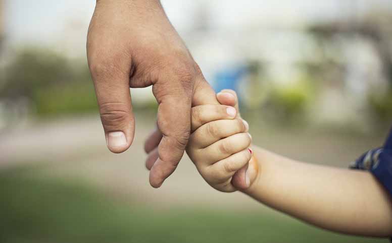 Isä ja lapsi käsikädessä