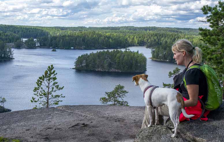 Koira ja nainen patikoimassa