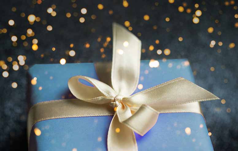 Sininen lahjapaketti ja kultainen lahjanauha