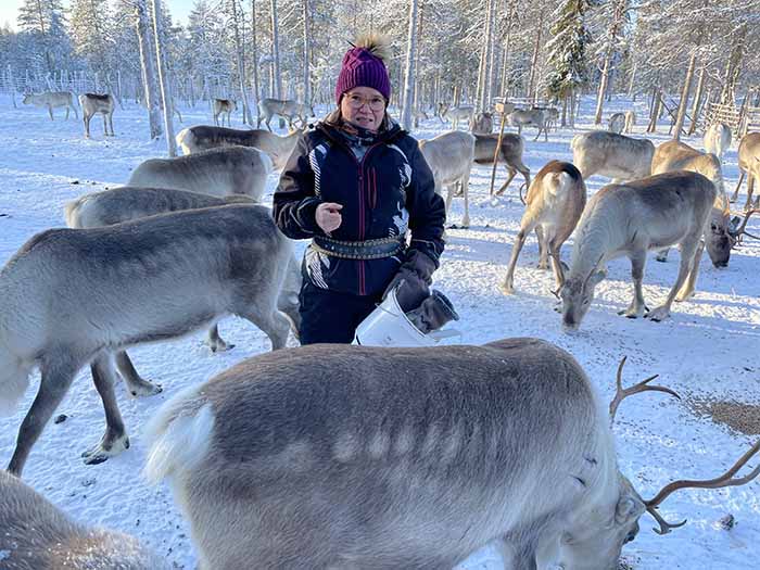 Porohaan Katja Alajärvi vie vierailijan ruokkimaan poroja ja kertoo samalla porotilan arjesta. Kuva: Matti Remes