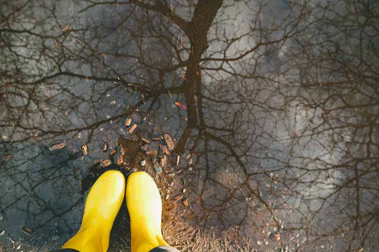 Keltaiset kumisaappaat vesilätäkössä