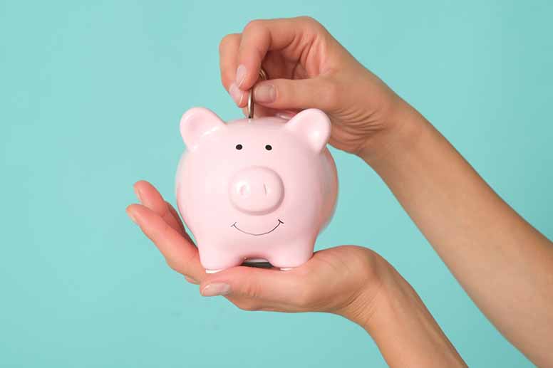 Nainen pitää kädessään valkoista säästöpossua