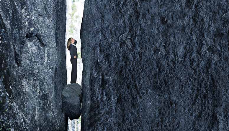 Nainen on ansassa kallioseinämien välissä