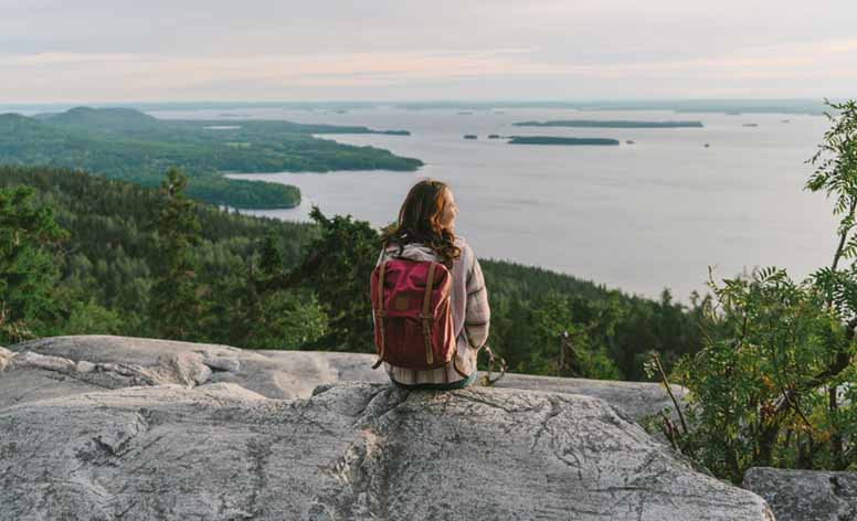 Nainen katselee järvimaisemaa