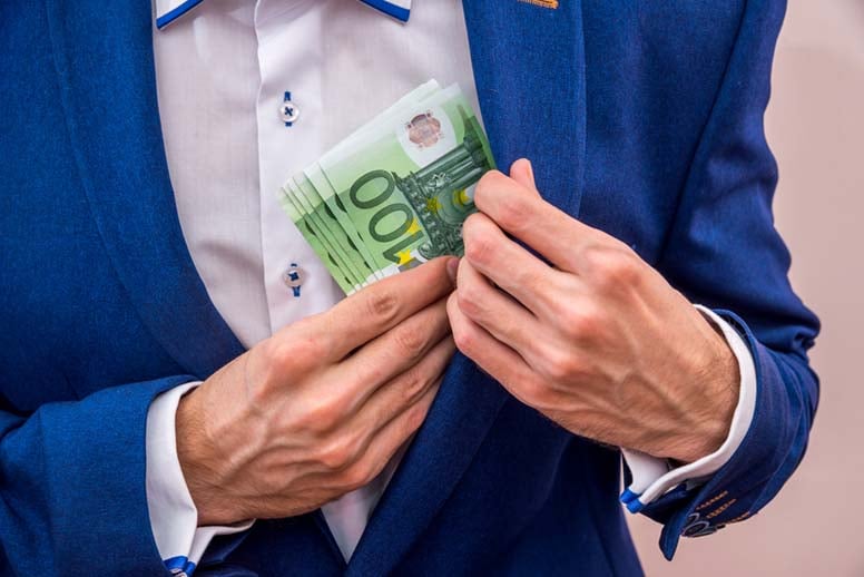 Mies laittaa rahaa taskuun