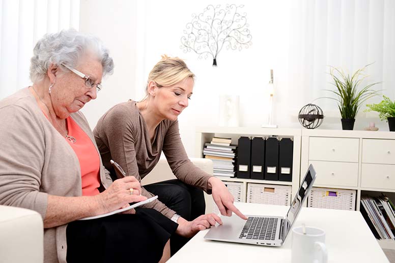 Isoäiti ja tytär etsivät tietoa tietokoneella
